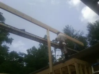Carpenter setting a ridge beam over a new addition frame — Ice Dam Removal by Roofing Brothers in Haywood