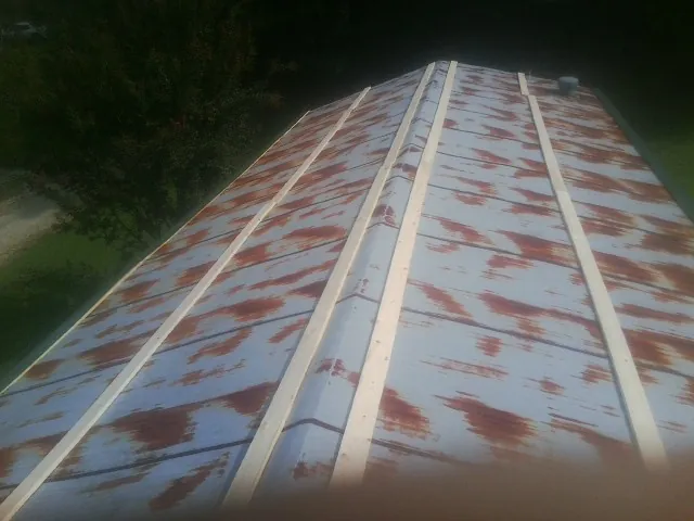 Rusted metal roof panels with new wood purlins before replacement — Storm Damage Roof Repair in Haywood by Roofing Brothers