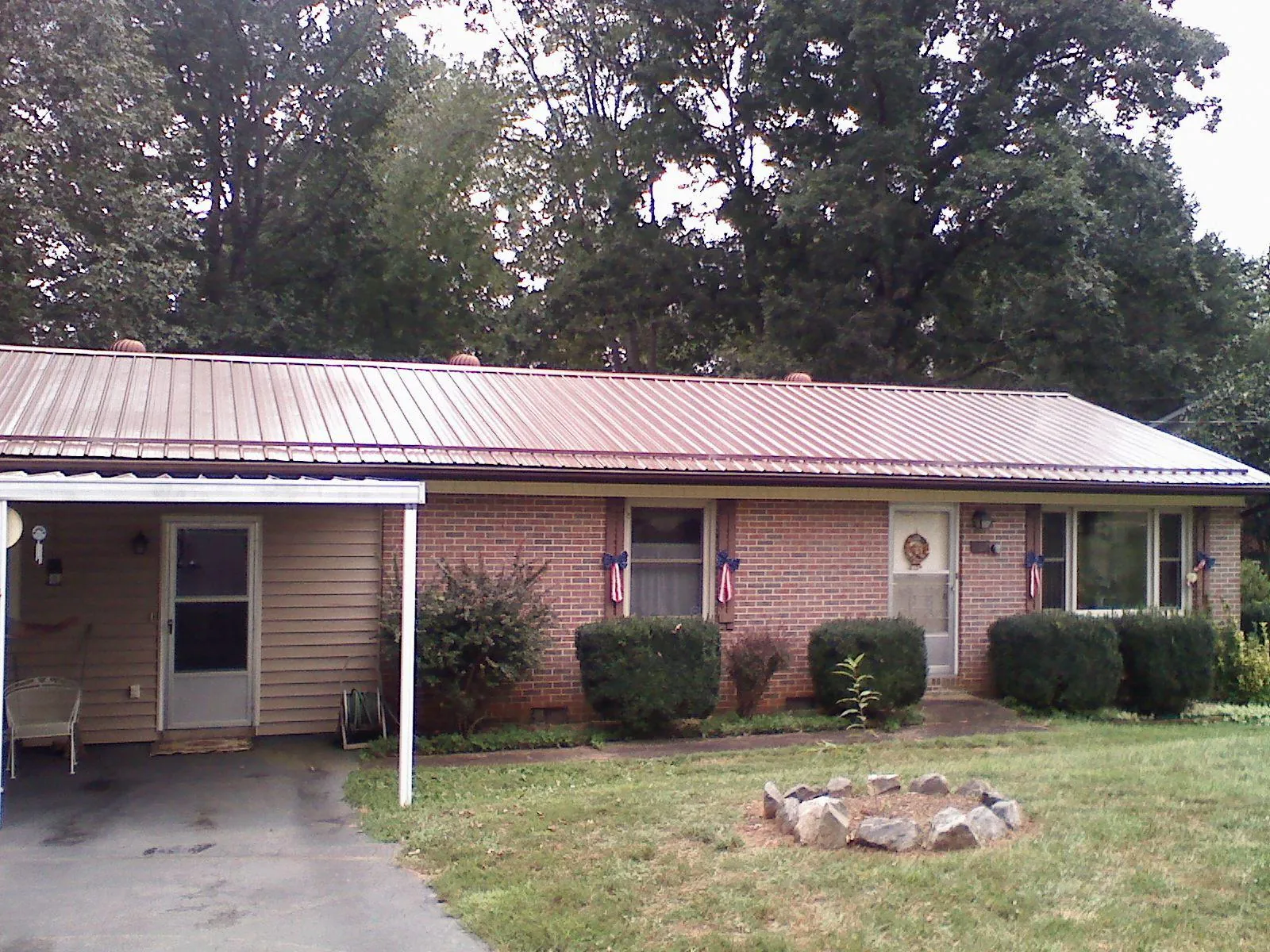 Bronze metal roof and carport on a brick ranch home — Roof Repair work by our crew in Haywood